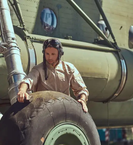 Military PCS Moving: Pilot inspecting aircraft tire before relocation. Secure & reliable moving services.